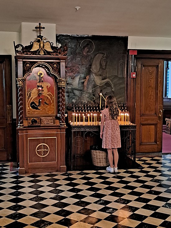 Sophie Dionis lights a candle before Divine Liturgy